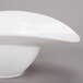 A 10 Strawberry Street Somba white porcelain oval rim bowl with a curved edge.