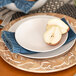 A white 10 Strawberry Street Wazee Matte stoneware salad plate with a pear half on it.
