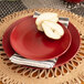 A red Wazee Matte stoneware salad plate with a pear on it.