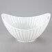 A white porcelain boat bowl with wavy line texture and a handle.