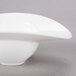 A white porcelain oval bowl with a curved edge.