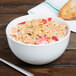 A 10 Strawberry Street Wazee Matte white stoneware cereal bowl filled with cereal and strawberries with a spoon.