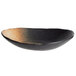 A black oval stoneware bowl with a brown rim.