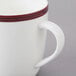 A close-up of a white 10 Strawberry Street Bistro mug with red trim on the rim.