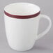 A close-up of a 10 Strawberry Street white mug with a red stripe on the rim.