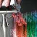 A hand pouring liquid into Choice clear plastic test tubes on a counter.