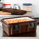 A dark brown Cambro food pan carrier with food inside.