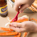 A person using a red WNA Comet Sea-Sheller to peel a crab leg.