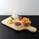 A Tablecraft wooden bread and charcuterie board with food on it.