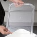 A person holding a clear plastic lid over a Cambro ingredient bin.