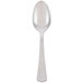 A Libbey stainless steel demitasse spoon with a white handle and a silver spoon.