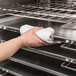 A hand using a white towel to clean a Vulcan stainless steel electric combi oven.