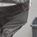 A Lavex black medium-duty trash bag with white drawstrings on a chair.