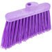 A close-up of a Carlisle medium duty angled broom head with purple flagged bristles.
