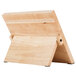 A Mercer Culinary Genesis rubberwood cutting board with a stand.