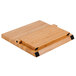 A wooden bamboo cutting board with black corners and a purple handle.