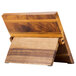 A wooden Mercer Culinary Millennia® cutting board with a stand.