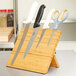 A Mercer Culinary bamboo magnetic knife rack holding knives.