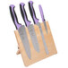 A set of Mercer Culinary Millennia® knives with purple handles on a wooden board.