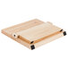 A Mercer Culinary Millennia Colors wooden cutting board with a purple stripe on a table.