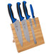 A Mercer Culinary Millennia Colors® knife set with blue handles on a bamboo magnetic board.