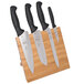 A Mercer Culinary Millennia® knife set on a bamboo magnetic board with black ovals.