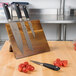 A Mercer Culinary Genesis knife set on a wooden board with a knife block.