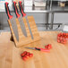 Mercer Culinary Millennia Colors® knife set with red handles on bamboo magnetic board with tomatoes.