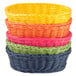 A stack of Tablecraft oval rattan bread baskets in assorted colors.