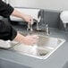 A person using a Cambro portable hand sink to wash their hands.