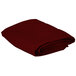 A folded burgundy Intedge square table cover.