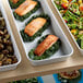 A white Cambro market pan with salmon, broccoli, and other vegetables on it.