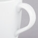 A close-up of a 10 Strawberry Street Classic White porcelain barrel mug with a handle.