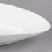 A close up of a 10 Strawberry Street Ricard white oval porcelain plate with a curved edge.