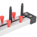 A metal bar with red and black Plate Mate WM12-350 wall mount racks for plates.