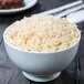 A 10 Strawberry Street Classic White oval porcelain footed rice bowl filled with brown rice on a table.