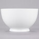 A white bowl with a white rim on a gray surface.