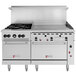 A large stainless steel Wolf commercial range with 4 burners, a griddle, and 2 ovens.