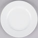 A white 10 Strawberry Street porcelain plate with a white rim on a gray surface.