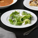 A 10 Strawberry Street Classic White porcelain salad plate with salad and soup on it.