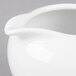 A close-up of a white 10 Strawberry Street porcelain creamer with a handle.