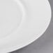 A close up of a 10 Strawberry Street Ricard white porcelain dinner plate with a white rim.