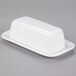 A 10 Strawberry Street white porcelain covered butter dish on a gray surface.
