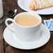 A 10 Strawberry Street Classic White porcelain cup of coffee on a saucer with a croissant.