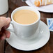 A person's hand holding a 10 Strawberry Street Classic White porcelain cup of coffee.