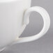 A close-up of a 10 Strawberry Street white porcelain coffee cup with a handle.