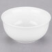 A white 10 Strawberry Street small oval porcelain rice bowl on a gray surface.