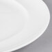 A close-up of a white porcelain oval platter with a white rim.