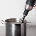 A KitchenAid blending arm attached to a metal container of liquid being stirred.
