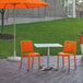 Grosfillex orange chairs on a stone patio.